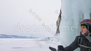 人们坐在冰窟附近的自行车旁。 有冰洞和冰柱的岩石非常美丽。 骑自行车的是